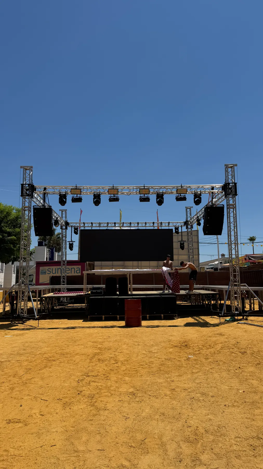 Montaje de escenario al aire libre con estructura de truss, focos, altavoces y pantalla LED